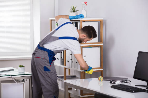 istock Male Cleaner Cleaning Shelf At Workplace 949224632
