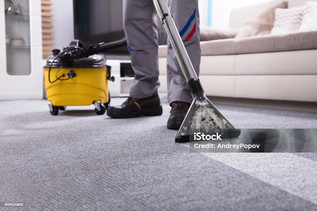 Person Cleaning Carpet With Vacuum Cleaner Low Section Of A Person Cleaning The Carpet With Vacuum Cleaner In Living Room Cleaning Stock Photo