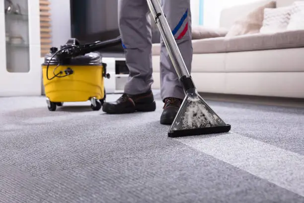 Photo of Person Cleaning Carpet With Vacuum Cleaner