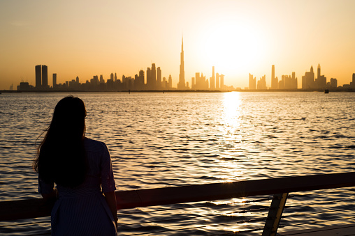 Woman enjoying the panoramic view of Dubai at sunset