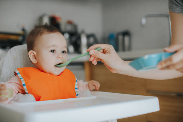istock Adult feeding baby 949234750