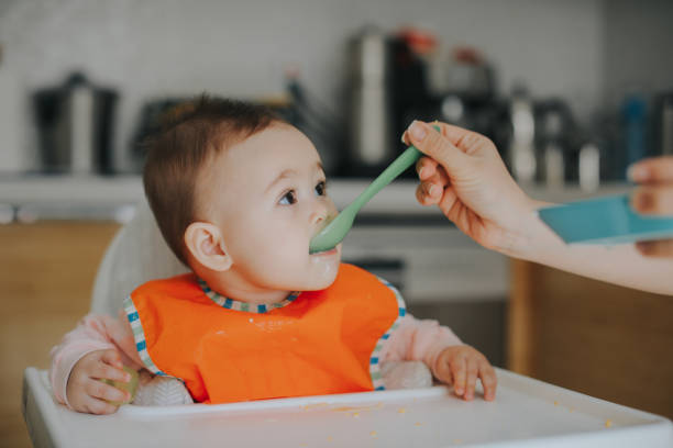 istock Adult feeding baby 949235380