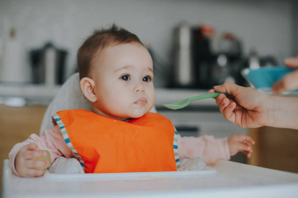 istock Adult feeding baby 949235876