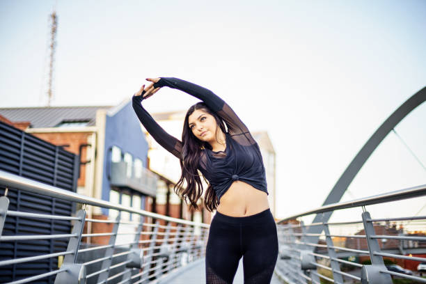 istock Young British Lady making a stretching exercises in a sunny England day in Coventry, UK 949251088