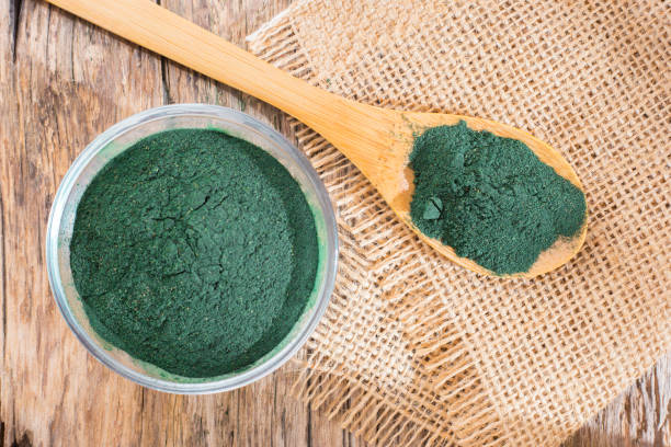 istock Spirulina powder and tablets on wooden background 949256016