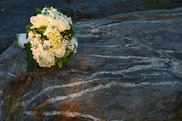 buquê de noiva branco colocar sobre uma grande pedra - foto de acervo