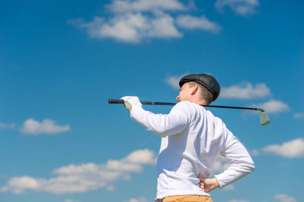 гольфист с клюшкой для гольфа трется больной обратно на поле - human spine human age horizontal outdoors стоковые фото и изображения