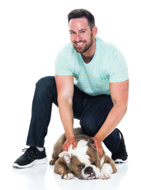 istock Happy young man playing with his bulldog 949268516
