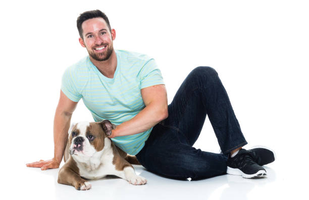 istock Happy young man playing with his bulldog 949268920