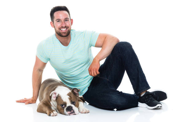 istock Happy young man playing with his bulldog 949269008