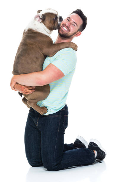 istock Happy young man playing with his bulldog 949269312