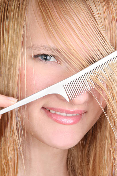 beautiful smiling girl combing her wet hair stock photo