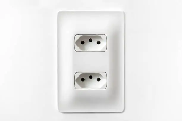 Double plug socket on the wall isolated on white background