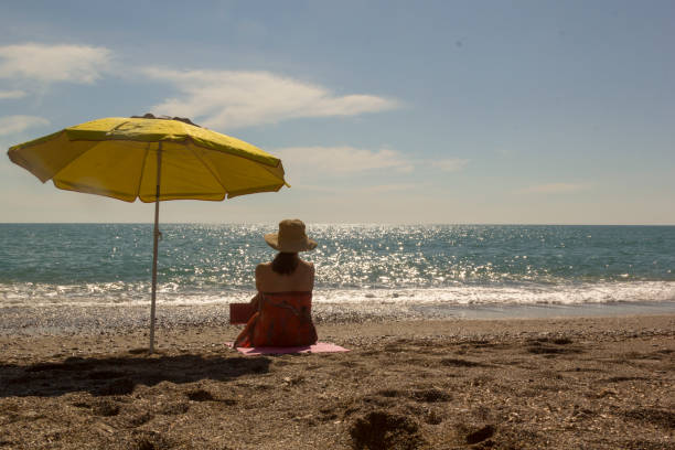 black hat woman sunbathing on the beachblack hat woman sunbathing on the beachblack hat woman sunbathing on the beach