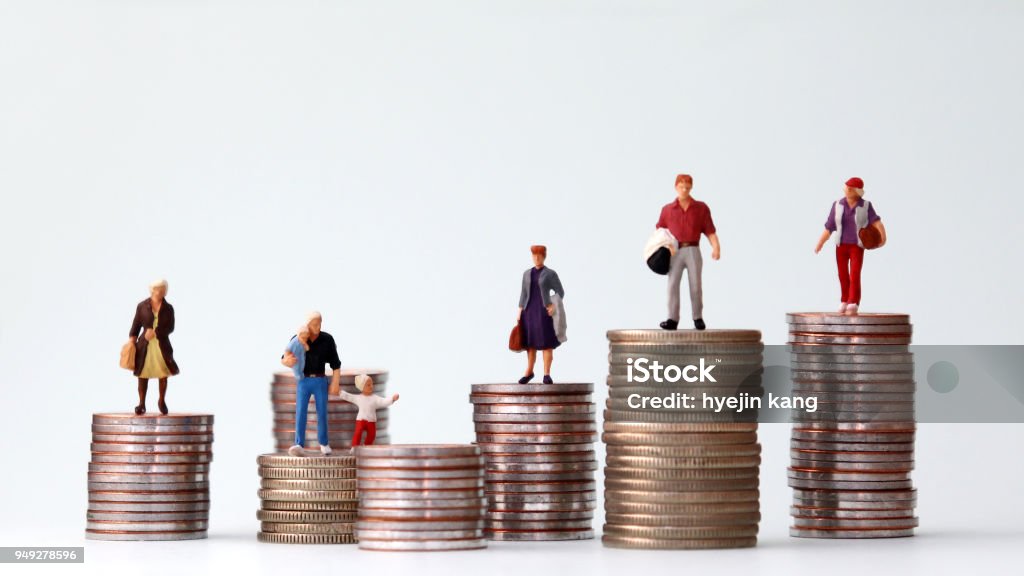 Miniature people standing on piles of different heights of coins. The concepts of person and wealth. Wealth Stock Photo