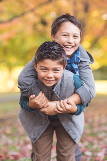 istock Two elementary-age boys walk to school through the park 949286522