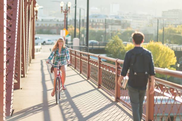 istock Woman Riding Bicycle Across City Bridge 949289092