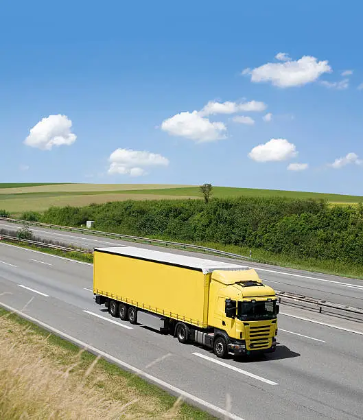 Photo of Blue sky over yellow truck on a highway