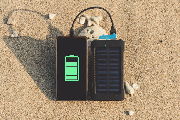tragbare solar-panel befindet sich am strand - recharger stock-fotos und bilder