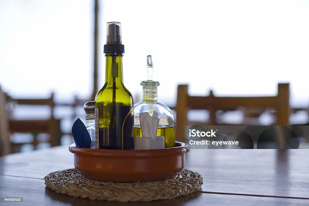 Azeite de oliva e vinagre de mesa no bar da praia, luz de fundo - Foto de stock de Bar royalty-free