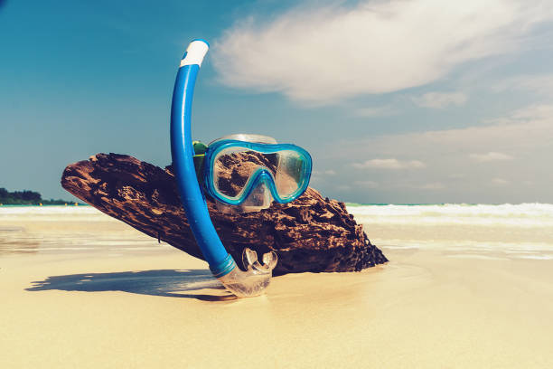 silicone mask for scuba diving or snorkeling on stones. Mask and tube for snorkeling on the sandy beach against the backdrop of the picturesque sea. Close-up view.