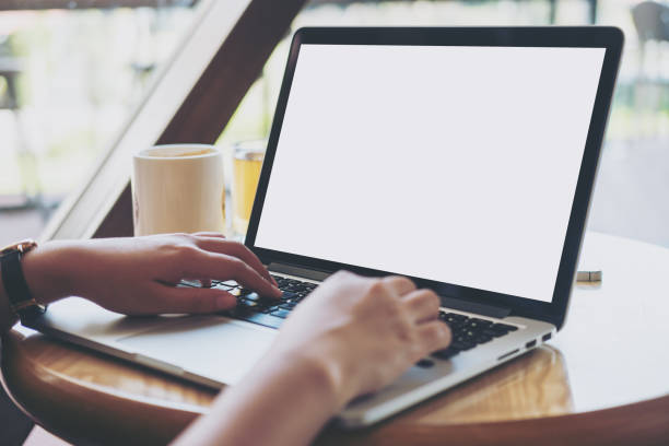 istock Mockup image of woman's hands using laptop with blank white screen 949303262