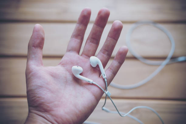 istock White earphones on the hand 949306220