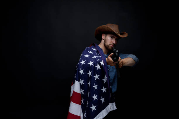 istock American man with rifle and American flag 949307368