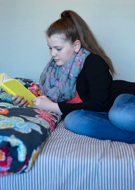 istock Young Teen Girl Reading Homework Assignment 949325244
