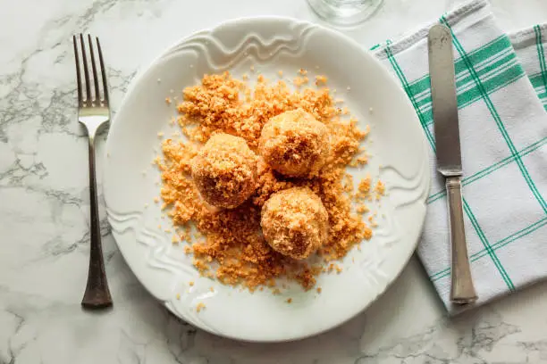 Sweet plum dumplings on plate with bred crumbs. Traditional Hungarian food made from potatoe dough filled with plums. Serving size, ready to eat.