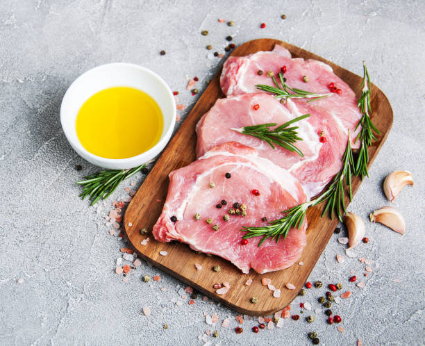 istock Fresh raw pork chops with spices and herbs 949337128