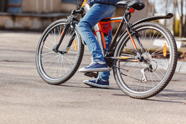 istock Child on a bicycle at asphalt road in sunny spring day 949337616