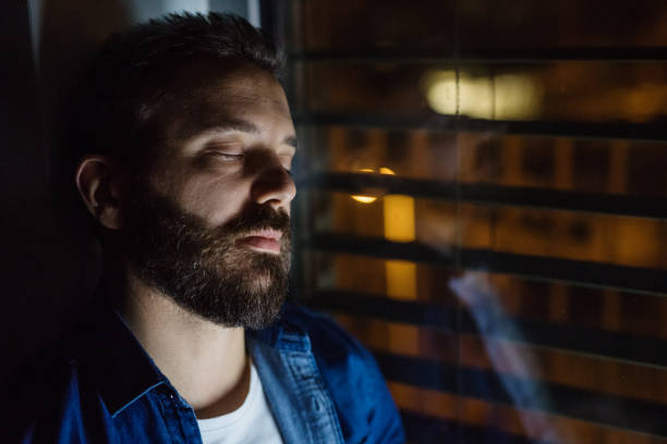 istock A man slepping by the window at home at night. 949346730
