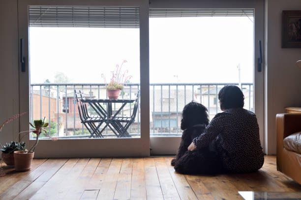 istock sad woman sitting and looking out the window 949350812