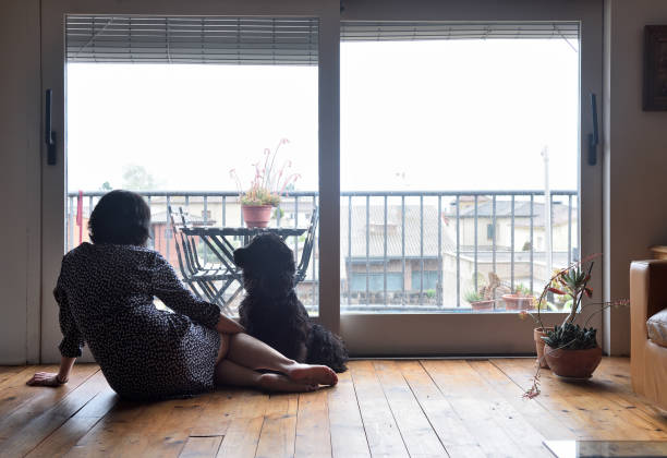 istock sad woman sitting and looking out the window 949350816