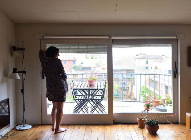 istock sad woman sitting and looking out the window 949351188