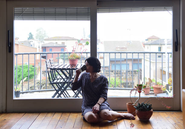 istock sad woman sitting and looking out the window 949351218