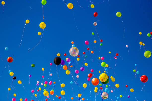istock Multicolored balloons fly in the blue sky 949351262