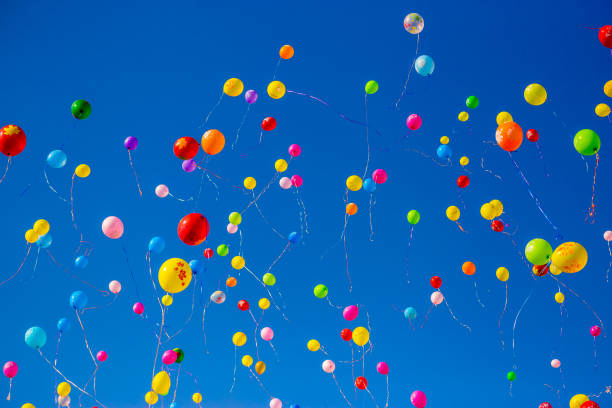 istock Multicolored balloons fly in the blue sky 949351326