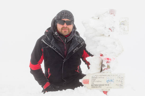istock An equipped tourist beside a frozen direction sign 949351414