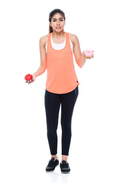 istock Woman in exercise clothes choosing between apple and donut 949359902