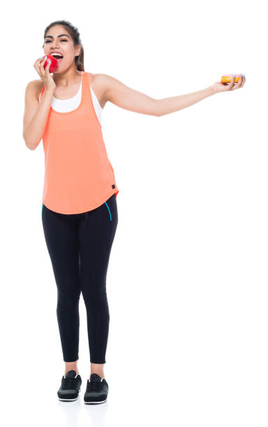 istock Woman in exercise clothes choosing between apple and donut 949360004