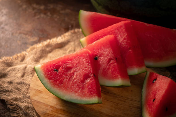 istock watermelon and watermelon pieces in a wooden background 949360746