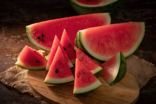 istock watermelon and watermelon pieces in a wooden background 949360882