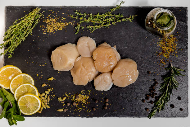 istock Scallop in shell lies on black dish 949361380