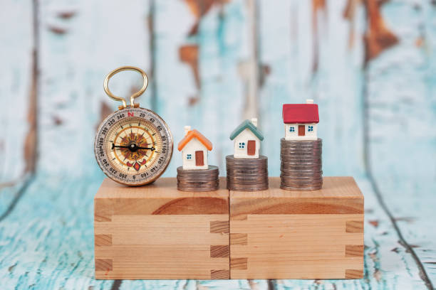 istock miniature house on coin stack on wood stand with wood  wall . 949362332