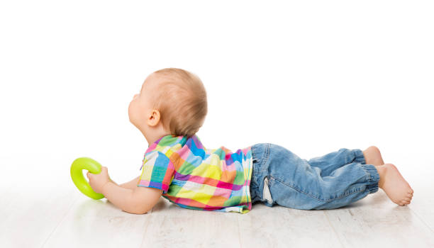 Baby Lying on White Floor, Child Back Rear View Looking Away, Kid Raised Head