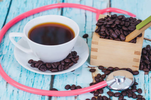 istock hot coffee cup with stethoscope on wood table. 949364894