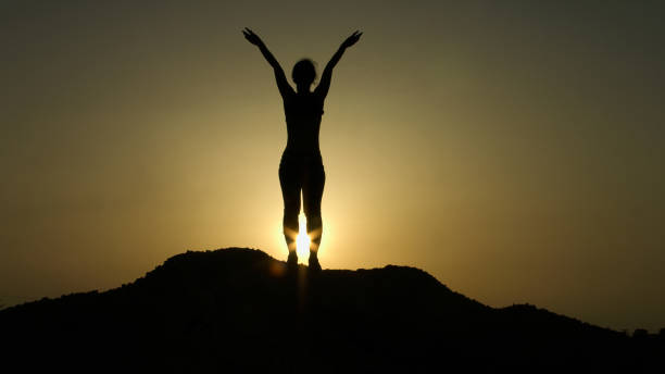 istock Young female doing stretching exercises early in morning on mountain top 949366320