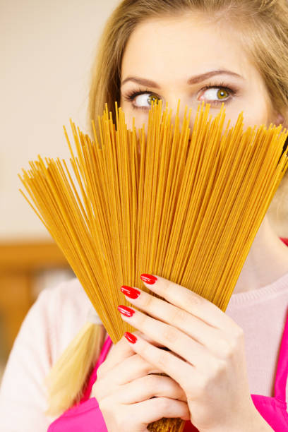 istock Woman hiding behind long pasta 949369192